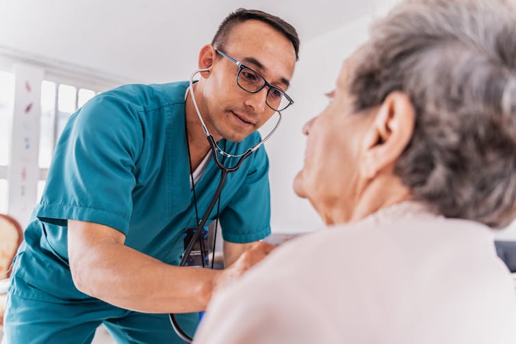 The nurse listened to the heart of a high woman during medical communication